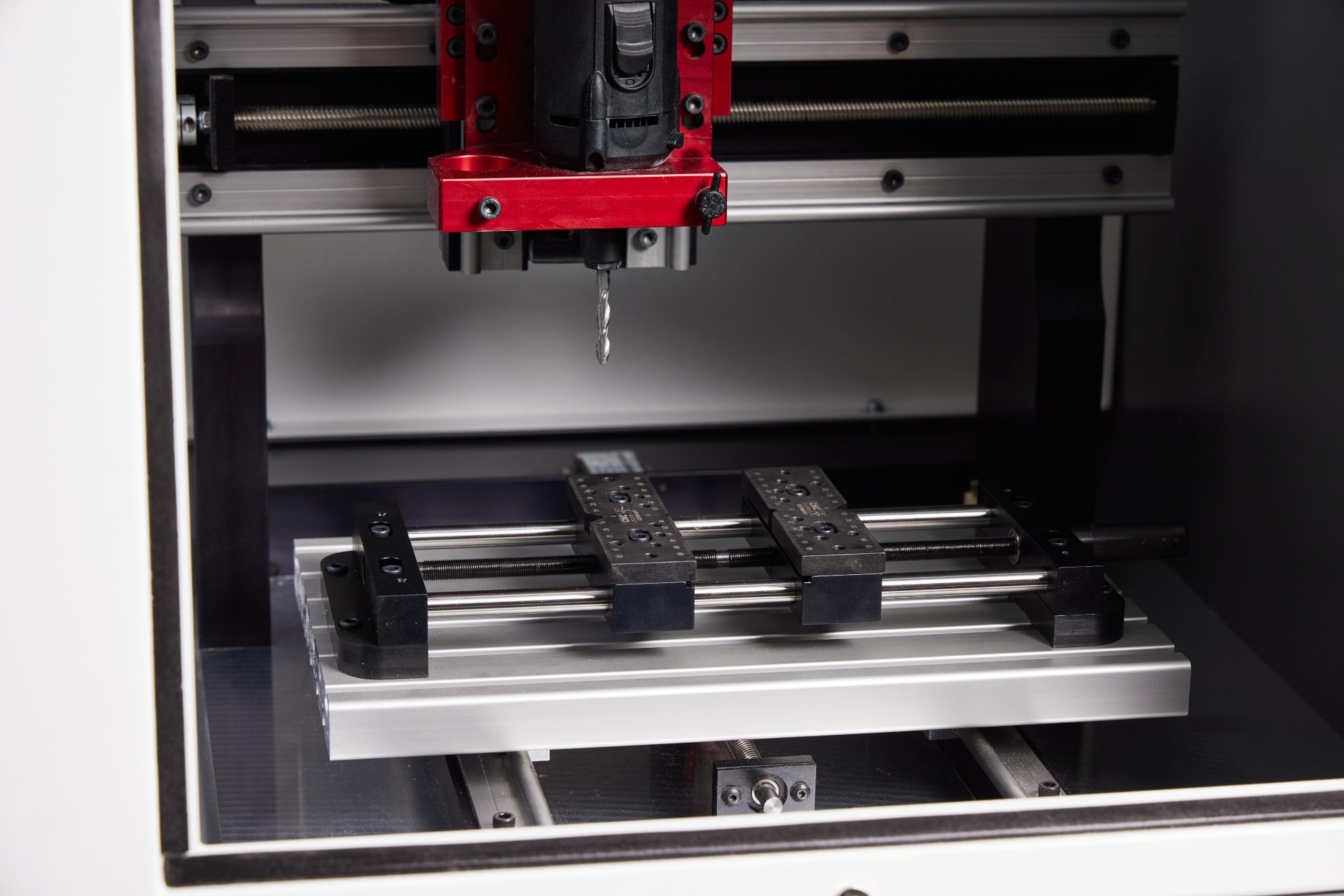 Work holding fixtures and material positioned beneath the spindle
